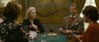 Movie still from “The Walker” (2007), directed by Paul Schrader – A group of people sitting at a table playing cards; Medium shot, Over the shoulder angle