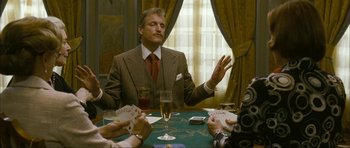 Movie still from “The Walker” (2007), directed by Paul Schrader – A man sitting at a table with cards in front of him; Medium shot, Over the shoulder angle