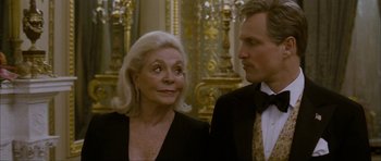 Movie still from “The Walker” (2007), directed by Paul Schrader – An older woman and a younger man standing next to each other; Close Up shot, Over the shoulder angle