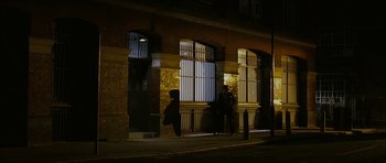 Movie still from “The Walker” (2007), directed by Paul Schrader – Two people walking on a sidewalk at night; Extreme Wide shot, Low angle