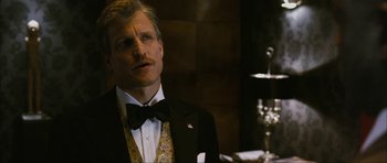 Movie still from “The Walker” (2007), directed by Paul Schrader – A man in a tuxedo standing in front of a table; Close Up shot, Over the shoulder angle