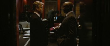 Movie still from “The Walker” (2007), directed by Paul Schrader – Two men in business suits talking to each other; Medium shot, Over the shoulder angle