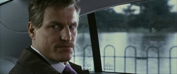 Movie still from “The Walker” (2007), directed by Paul Schrader – A person wearing a suit and tie; Close Up shot, Over the shoulder angle