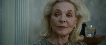 Movie still from “The Walker” (2007), directed by Paul Schrader – An older woman with long blonde hair wearing gold earrings; Close Up shot, Over the shoulder angle