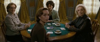 Movie still from “The Walker” (2007), directed by Paul Schrader – Two women sitting at a table playing cards; Medium shot, High angle