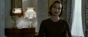 Movie still from “The Walker” (2007), directed by Paul Schrader – A woman standing in front of a lamp in a room; Close Up shot, Over the shoulder angle