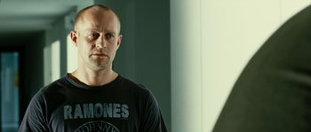 Movie still from “The Wave” (2008), directed by Dennis Gansel – A man in a black shirt is standing in front of a mirror; Close Up shot, Low angle