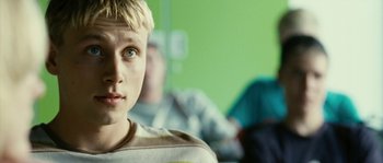 Movie still from “The Wave” (2008), directed by Dennis Gansel – A young man with blonde hair and a striped shirt; Close Up shot, Low angle
