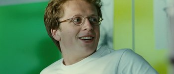 Movie still from “The Wave” (2008), directed by Dennis Gansel – A man with glasses is smiling for the camera; Close Up shot, Over the shoulder angle