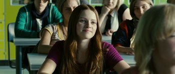 Movie still from “The Wave” (2008), directed by Dennis Gansel – A woman sitting in front of a group of other people; Medium shot, Over the shoulder angle