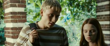 Movie still from “The Wave” (2008), directed by Dennis Gansel – A young man holding a backpack while standing in front of a tree; Close Up shot, Low angle