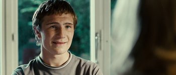 Movie still from “The Wave” (2008), directed by Dennis Gansel – A young man smiling for the camera; Close Up shot, Over the shoulder angle