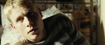 Movie still from “The Wave” (2008), directed by Dennis Gansel – A man laying on a bed in a room; Close Up shot, Low angle