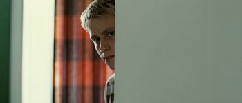 Movie still from “The Wave” (2008), directed by Dennis Gansel – A young man is looking over a white wall; Close Up shot, Low angle