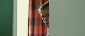 Movie still from “The Wave” (2008), directed by Dennis Gansel – A young man standing in front of a wall; Close Up shot, Over the shoulder angle