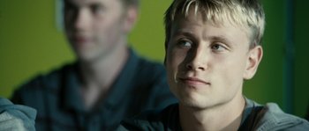 Movie still from “The Wave” (2008), directed by Dennis Gansel – A young man with blonde hair and blue eyes looking up; Close Up shot, Over the shoulder angle