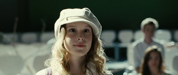 Movie still from “The Wave” (2008), directed by Dennis Gansel – A woman wearing a white hat looking to her left; Close Up shot, Over the shoulder angle