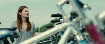 Movie still from “The Wave” (2008), directed by Dennis Gansel – A bicycle with a woman in the background; Medium shot, Over the shoulder angle