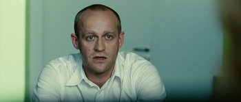 Movie still from “The Wave” (2008), directed by Dennis Gansel – A man in a white shirt is looking at the camera; Close Up shot, Over the shoulder angle