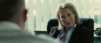 Movie still from “The Wave” (2008), directed by Dennis Gansel – A woman sitting in an office chair in front of a window; Close Up shot, Over the shoulder angle