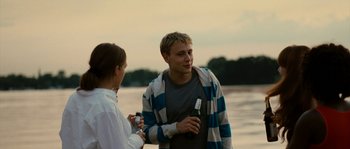 Movie still from “The Wave” (2008), directed by Dennis Gansel – A man and a woman standing next to a body of water; Medium shot, Over the shoulder angle