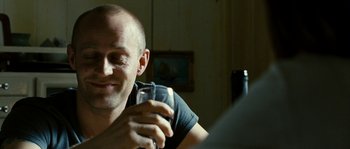 Movie still from “The Wave” (2008), directed by Dennis Gansel – A man sitting at a table holding a wine glass; Close Up shot, Over the shoulder angle
