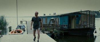 Movie still from “The Wave” (2008), directed by Dennis Gansel – A man walking down the side of a dock; Wide shot, Low angle