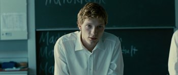 Movie still from “The Wave” (2008), directed by Dennis Gansel – A man in a white shirt is sitting in front of a chalkboard; Close Up shot, Low angle