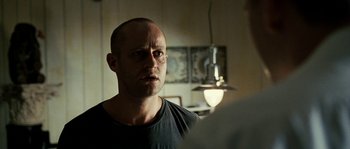 Movie still from “The Wave” (2008), directed by Dennis Gansel – A man in a black t - shirt is looking into the mirror; Close Up shot, Over the shoulder angle