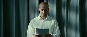 Movie still from “The Wave” (2008), directed by Dennis Gansel – A man in a white shirt is reading a piece of paper; Close Up shot, Low angle
