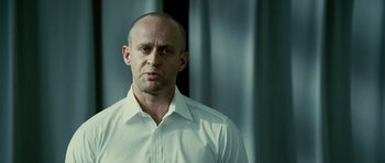 Movie still from “The Wave” (2008), directed by Dennis Gansel – A man with a shaved head wearing a white shirt; Close Up shot, Low angle