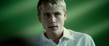 Movie still from “The Wave” (2008), directed by Dennis Gansel – A young man with blonde hair wearing a white shirt; Close Up shot, Over the shoulder angle