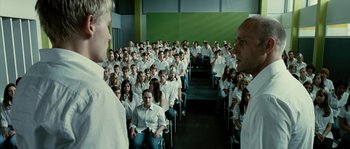 Movie still from “The Wave” (2008), directed by Dennis Gansel – A large group of people sitting in a room; Wide shot, High angle