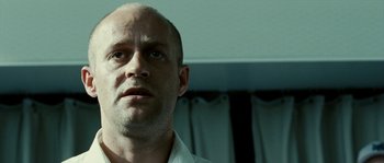 Movie still from “The Wave” (2008), directed by Dennis Gansel – A man with a bald head looking into the camera; Close Up shot, Low angle
