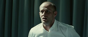 Movie still from “The Wave” (2008), directed by Dennis Gansel – A man in a white shirt is looking at the camera; Close Up shot, Low angle