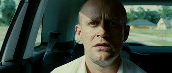 Movie still from “The Wave” (2008), directed by Dennis Gansel – A man with a bald head is sitting in the back of a car; Close Up shot, Low angle