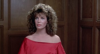 Movie still from “The Woman in Red” (1984), directed by Gene Wilder – A woman in a red dress with long curly hair; Close Up shot, Over the shoulder angle