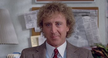 Movie still from “The Woman in Red” (1984), directed by Gene Wilder – A person wearing a suit and tie; Close Up shot, Over the shoulder angle