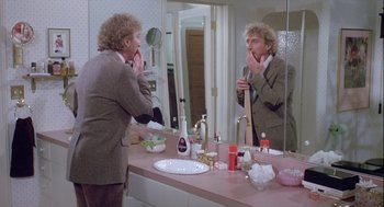 Movie still from “The Woman in Red” (1984), directed by Gene Wilder – A man is looking in the mirror in the bathroom; Medium shot, Over the shoulder angle