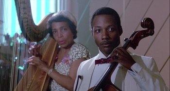Movie still from “The Woman in Red” (1984), directed by Gene Wilder – A man and a woman are holding musical instruments; Close Up shot, Low angle