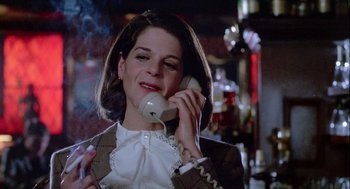 Movie still from “The Woman in Red” (1984), directed by Gene Wilder – A woman talking on a phone while smoking a cigarette; Close Up shot, Low angle
