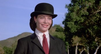 Movie still from “The Woman in Red” (1984), directed by Gene Wilder – A woman wearing a suit and tie and a top hat; Close Up shot, Low angle