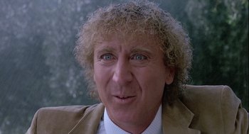 Movie still from “The Woman in Red” (1984), directed by Gene Wilder – An older man with curly blonde hair wearing a suit and tie; Close Up shot, Over the shoulder angle