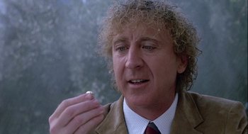 Movie still from “The Woman in Red” (1984), directed by Gene Wilder – A person holding something in his hand; Close Up shot, Over the shoulder angle