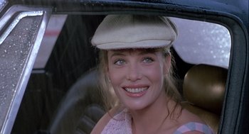 Movie still from “The Woman in Red” (1984), directed by Gene Wilder – A woman with a hat sitting in a car; Close Up shot, Over the shoulder angle