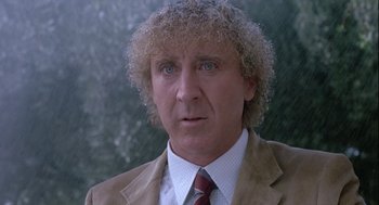 Movie still from “The Woman in Red” (1984), directed by Gene Wilder – A person wearing a suit and tie; Close Up shot, Low angle