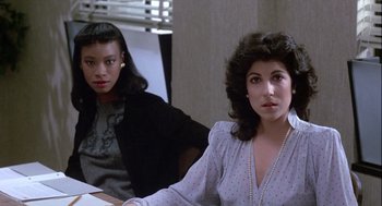 Movie still from “The Woman in Red” (1984), directed by Gene Wilder – Two women sitting at a table in front of a window; Medium shot, High angle