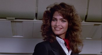 Movie still from “The Woman in Red” (1984), directed by Gene Wilder – A woman in a suit and tie smiling for the camera; Close Up shot, Low angle