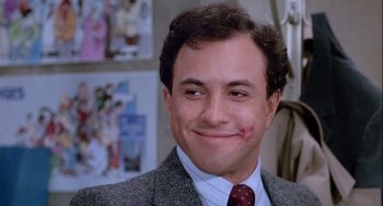 Movie still from “The Woman in Red” (1984), directed by Gene Wilder – A person wearing a suit and tie; Close Up shot, Over the shoulder angle