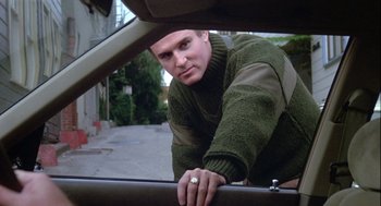 A man leaning on the side of a car looking out the window